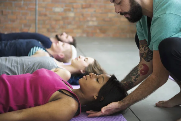 Coach helping woman on yoga — Stock Photo, Image