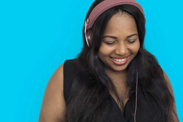 Mujer africana escuchando música en auriculares — Foto de Stock