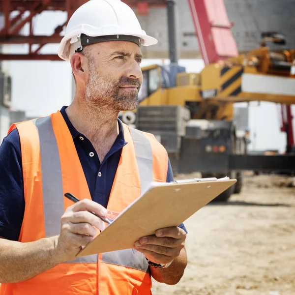 Obrero de la construcción con plan de arquitectura —  Fotos de Stock