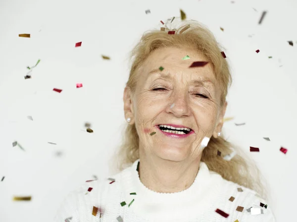 Yaşlı kadın ve renkli konfeti — Stok fotoğraf