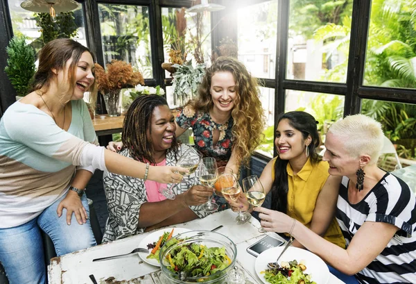 Mujeres jóvenes tintineo bebidas — Foto de Stock