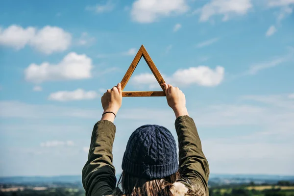 Женщина держит деревянный треугольник — стоковое фото