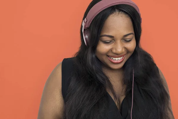 Mujer africana escuchando música en auriculares —  Fotos de Stock