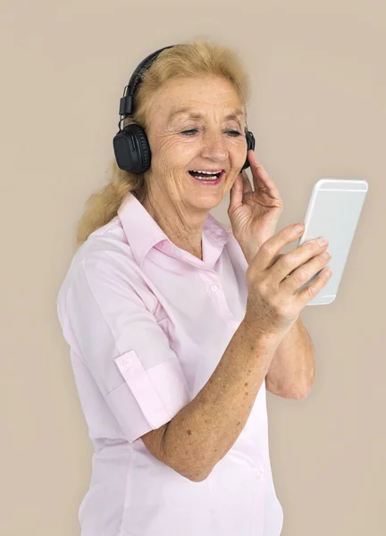 Ηλικιωμένη γυναίκα ακούει μουσική στα ακουστικά — Φωτογραφία Αρχείου