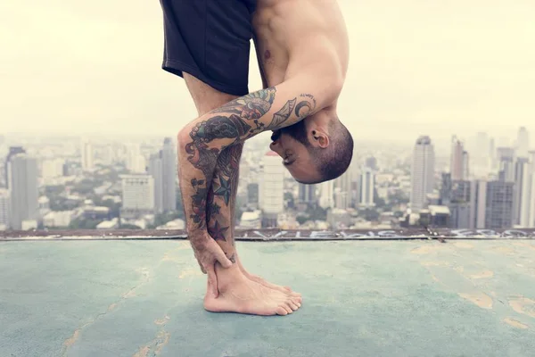 Homme pratiquant le yoga sur le toit — Photo