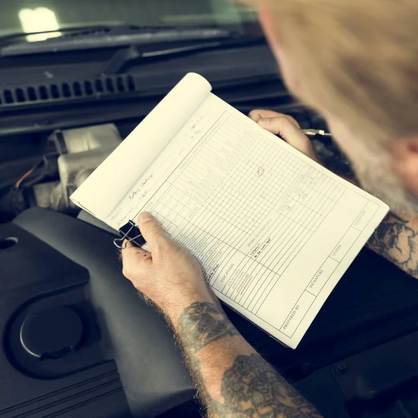 Car Mechanic pisania notatek — Zdjęcie stockowe