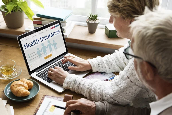 Senior couple using laptop at home — Stock Photo, Image