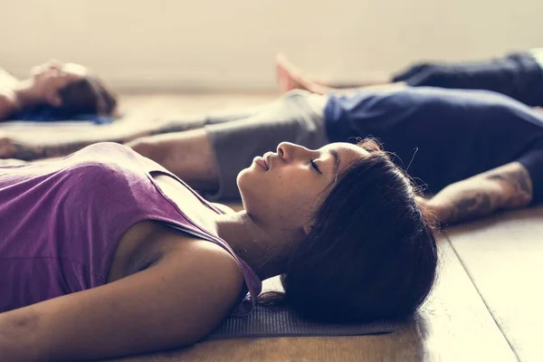 Люди роблять Shavasana в йога — стокове фото