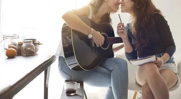Lesbian Couple playing on guitar