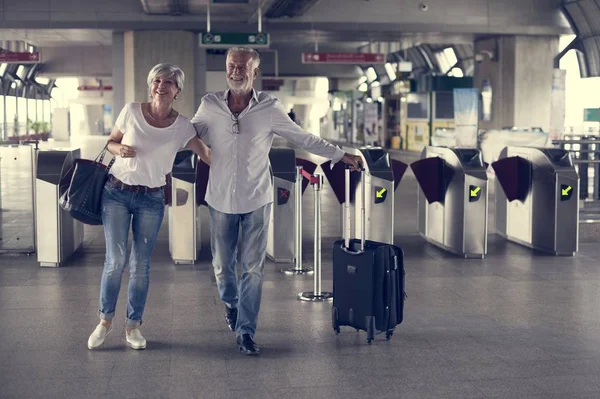 Casal sênior andando na estação ferroviária — Fotografia de Stock