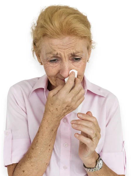 Senior kobieta dmuchanie nosa — Zdjęcie stockowe