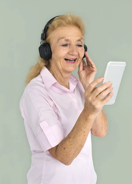 Ηλικιωμένη γυναίκα ακούει μουσική στα ακουστικά — Φωτογραφία Αρχείου