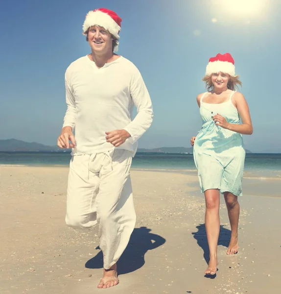 Couple wearing santa hats on the Beach — Stock Photo, Image