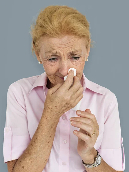 Пожилая женщина с заложенным носом — стоковое фото
