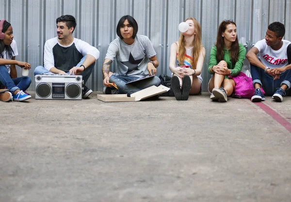 Друзья сидят на полу и слушают музыку — стоковое фото