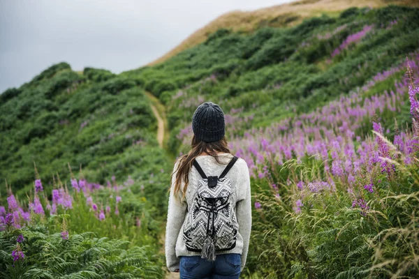 Женщина стоит в поле с цветами — стоковое фото