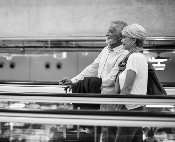 Casal no terminal do aeroporto equitação na escada rolante — Fotografia de Stock