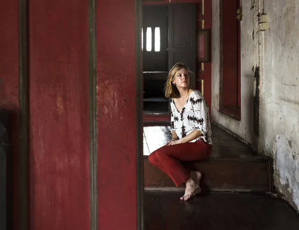 Jovem mulher sentada nas escadas — Fotografia de Stock