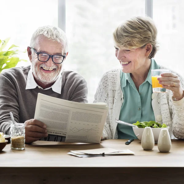 Pareja mayor leyendo periódico — Foto de Stock