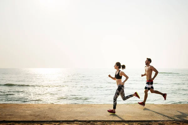 Mulher e homem correndo na praia — Fotografia de Stock