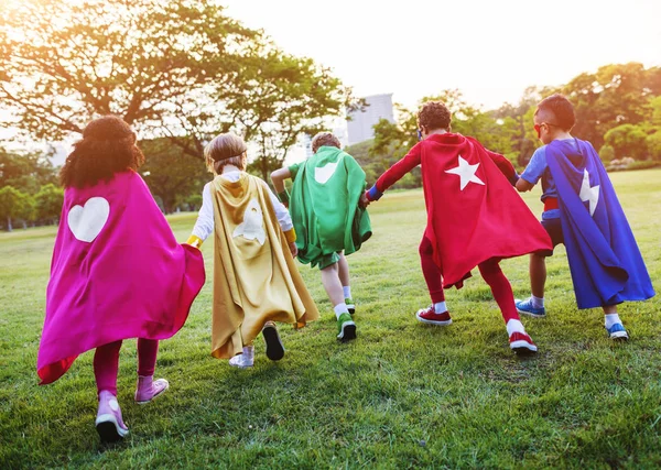 Children in superhero costumes in the park — Stock Photo, Image