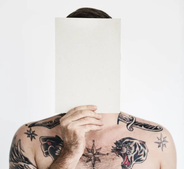 Homem com tatuagens segurando papel — Fotografia de Stock