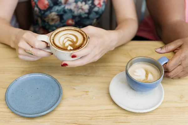 Unge kvinder drikker kaffe - Stock-foto