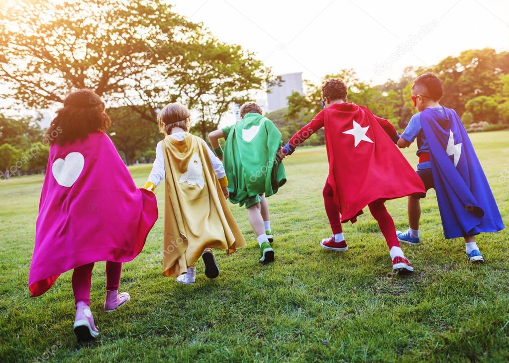 children in superhero costumes in the park