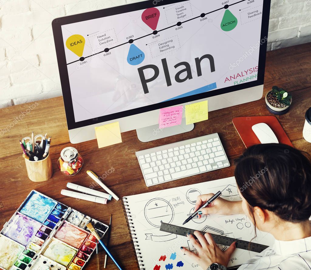 Woman working in art studio, workplace table with colorful paint, art tools, keyboard, graphic designer concept, monitor screen with text: Plan