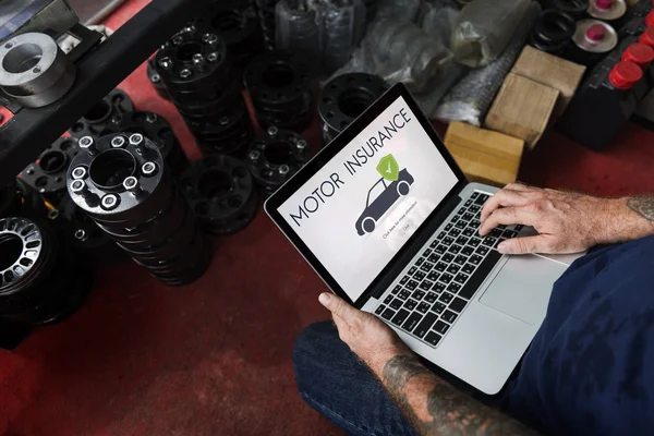 Bilmekaniker med laptop i garage — Stockfoto