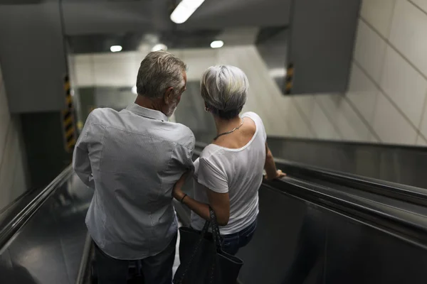 Paar fährt im Flughafen-Terminal auf Rolltreppe — Stockfoto