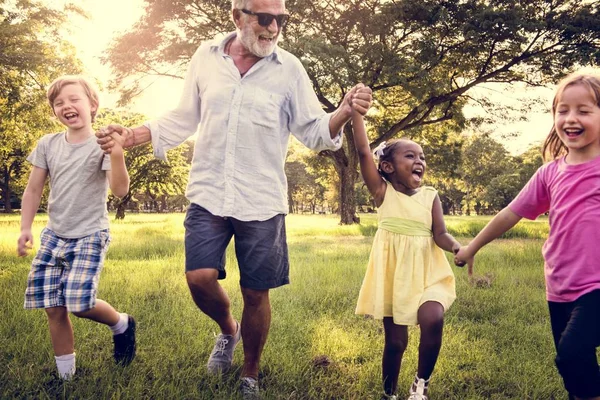 Grootvader met jonge geitjes in de zomer park — Stockfoto