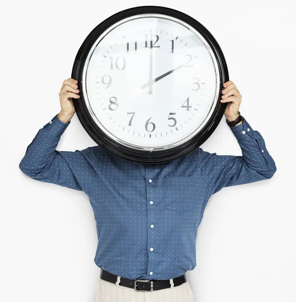 Hombre celebración reloj cubriendo la cara —  Fotos de Stock