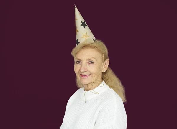 Mulher Sênior usando chapéu de festa — Fotografia de Stock