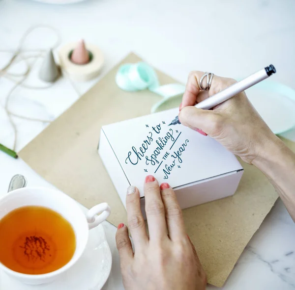 Mujer sosteniendo pluma y escritura — Foto de Stock