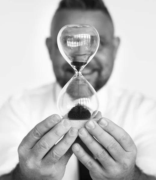 Empresário segurando relógio areia — Fotografia de Stock