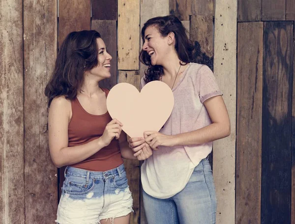 Lesblesbian pár se drží papír srdce — Stock fotografie