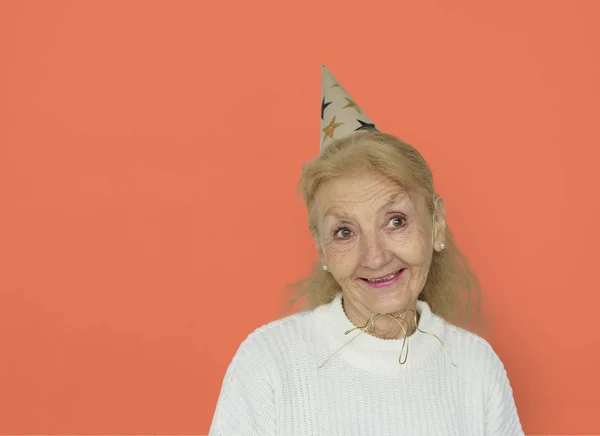 Mulher Sênior usando chapéu de festa — Fotografia de Stock