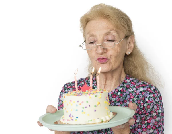 Sênior mulher soprando velas — Fotografia de Stock