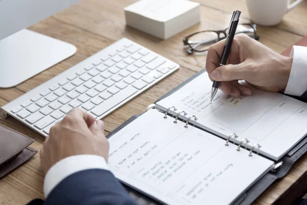 Geschäftsmann schreibt Notizen ins Tagebuch — Stockfoto