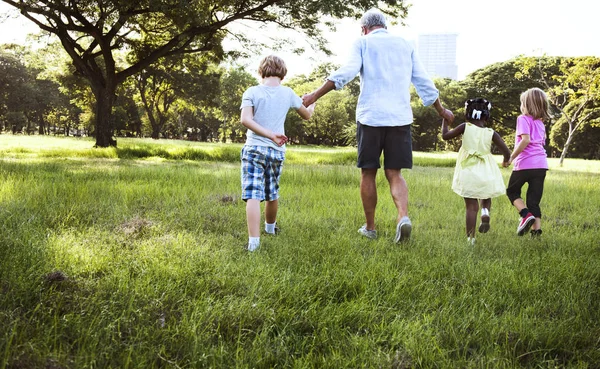 Дедушка с детьми в летнем парке — стоковое фото