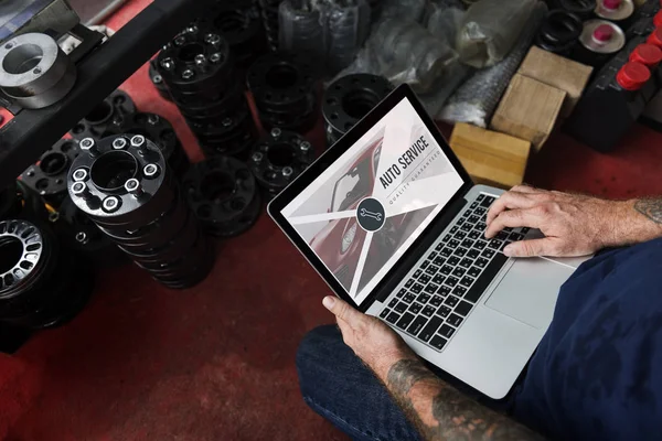 Auto monteur met laptop in garage — Stockfoto