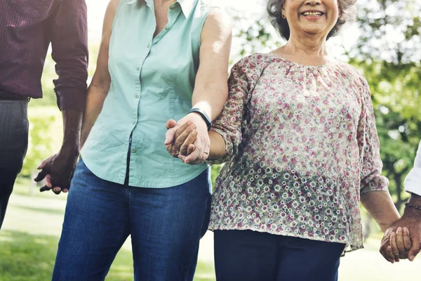 People holding hands in the park — Stock Photo, Image