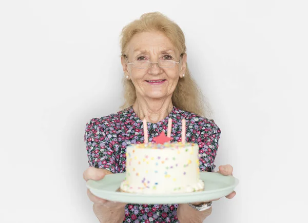 Senior mulher segurando bolo de aniversário — Fotografia de Stock