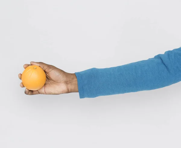 Human hand holding orange fruit — Stock Photo, Image