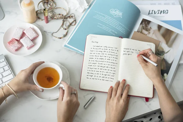 Mujer sosteniendo pluma y escritura — Foto de Stock