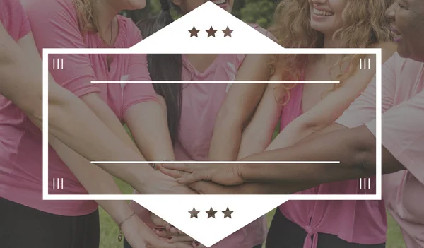 Kvinnor i rosa skjortor håller händerna — Stockfoto