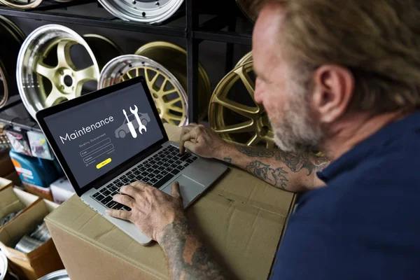 Mecânico de carro usando laptop na garagem — Fotografia de Stock