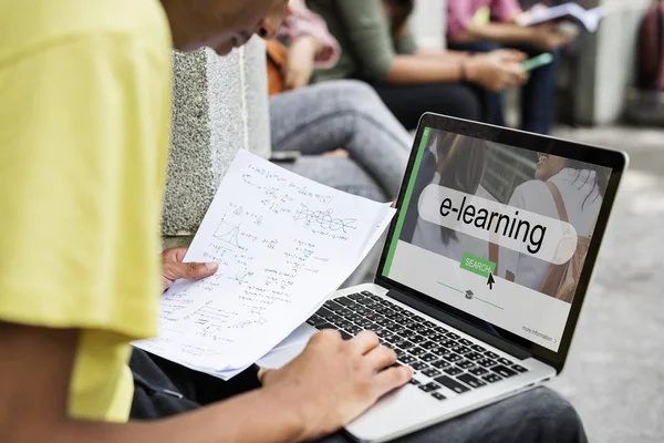 Student met behulp van laptop in straat — Stockfoto