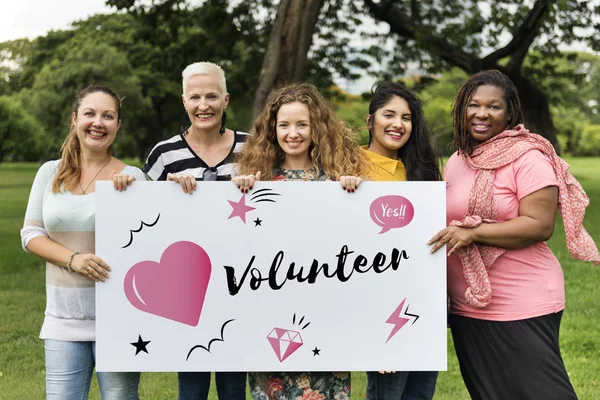 smiling women holding banner